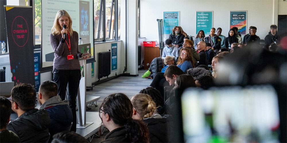 Kristin Ellingson speaking into a microphone to an audience of students