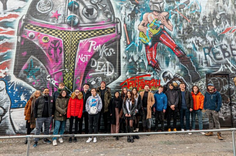 Students who took part in The CyberHub Trust creative challenge standing in front of a graffitied wall