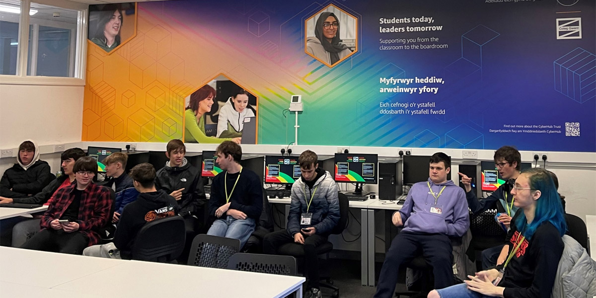 Students sitting in front of the new Cyberhub signage